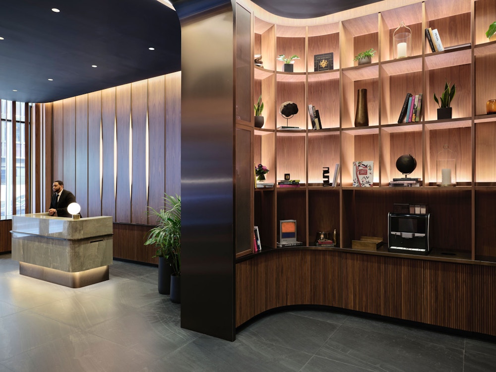 Library connected to reception through bronze-lined portal