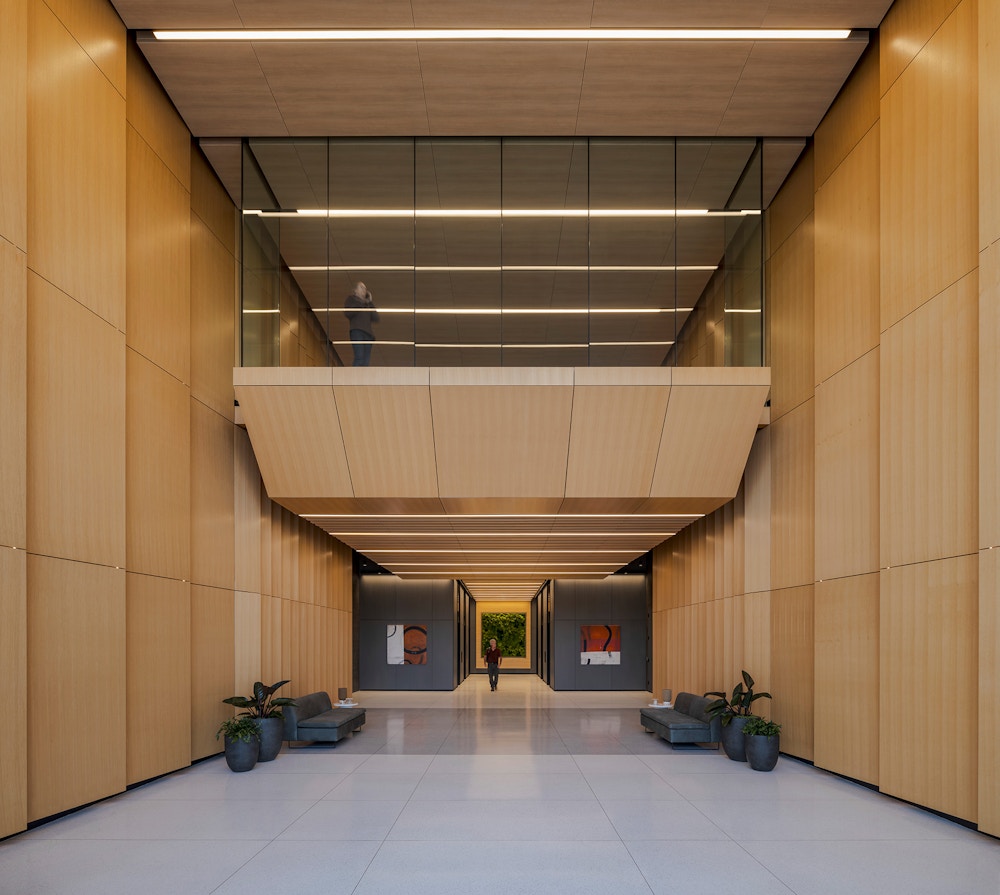 A beautiful wood-paneled lobby greets visitors and tenants with soft seating. 