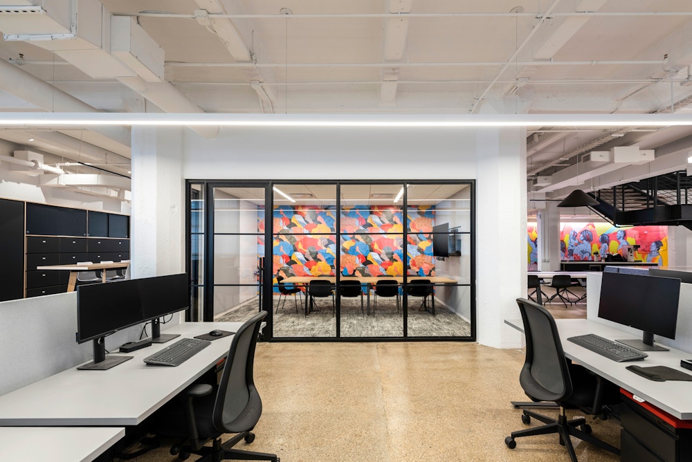 Open workstations and conference space featuring custom art