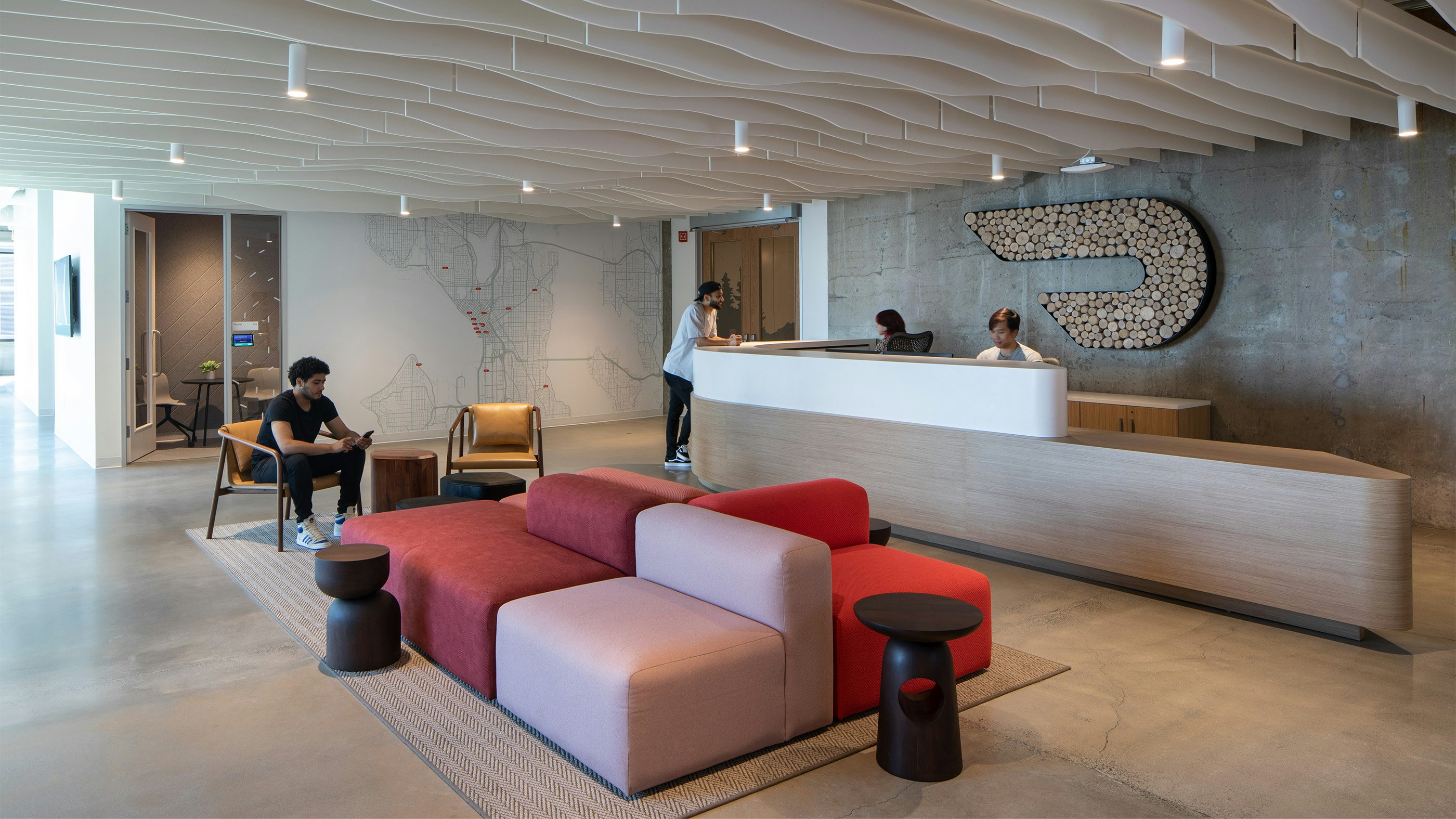 DoorDash Seattle lobby with custom swooping desk, a logo rendered in wood, and soft seating.